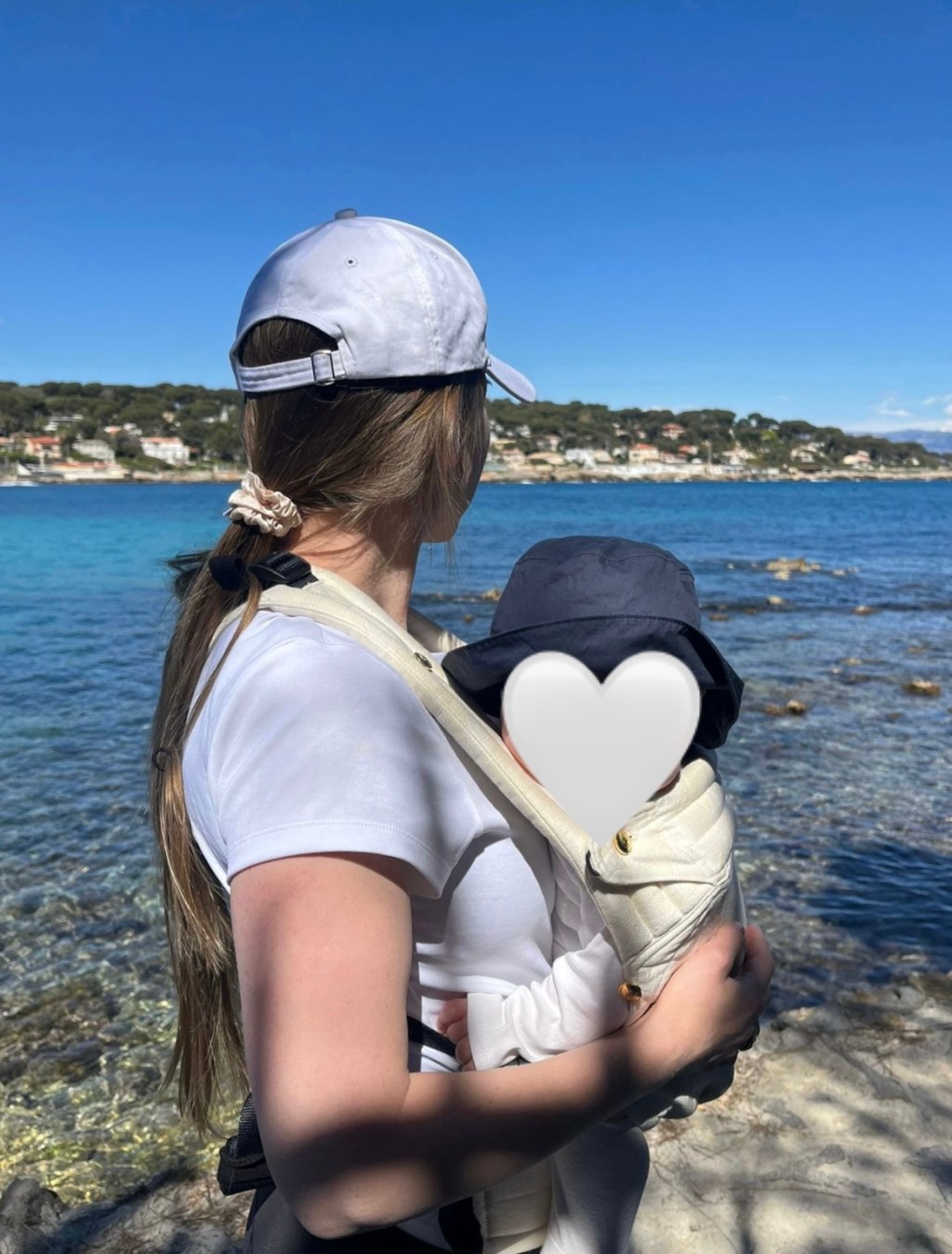 Woman holding her baby by the sea